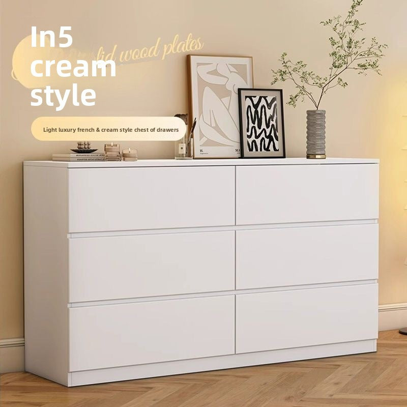 Cream tallboy dresser with multiple drawers and rounded edges