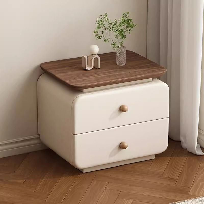 Neutral upholstered bedside table styled beside a modern bed