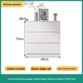 Cream chest of drawers styled beside a bed in a soft neutral bedroom