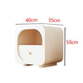 Cream bedside table with glass drawer front in a warm bedroom setting