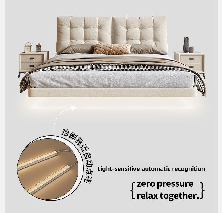 Cream storage bed with warm lighting and grounded bedroom styling