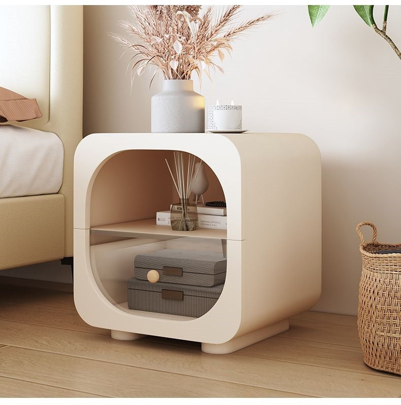 Small cream nightstand with warm neutral decor and a soft curved silhouette