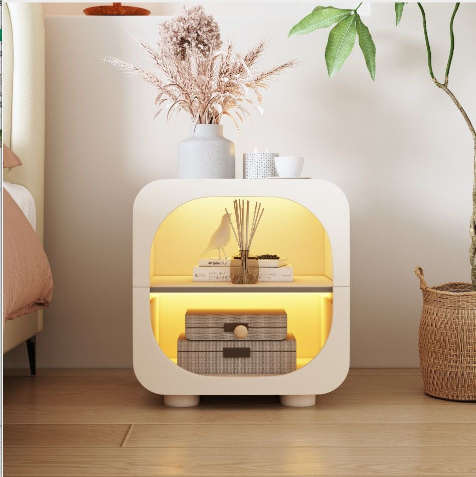 Modern cream nightstand centered beside an upholstered bed frame